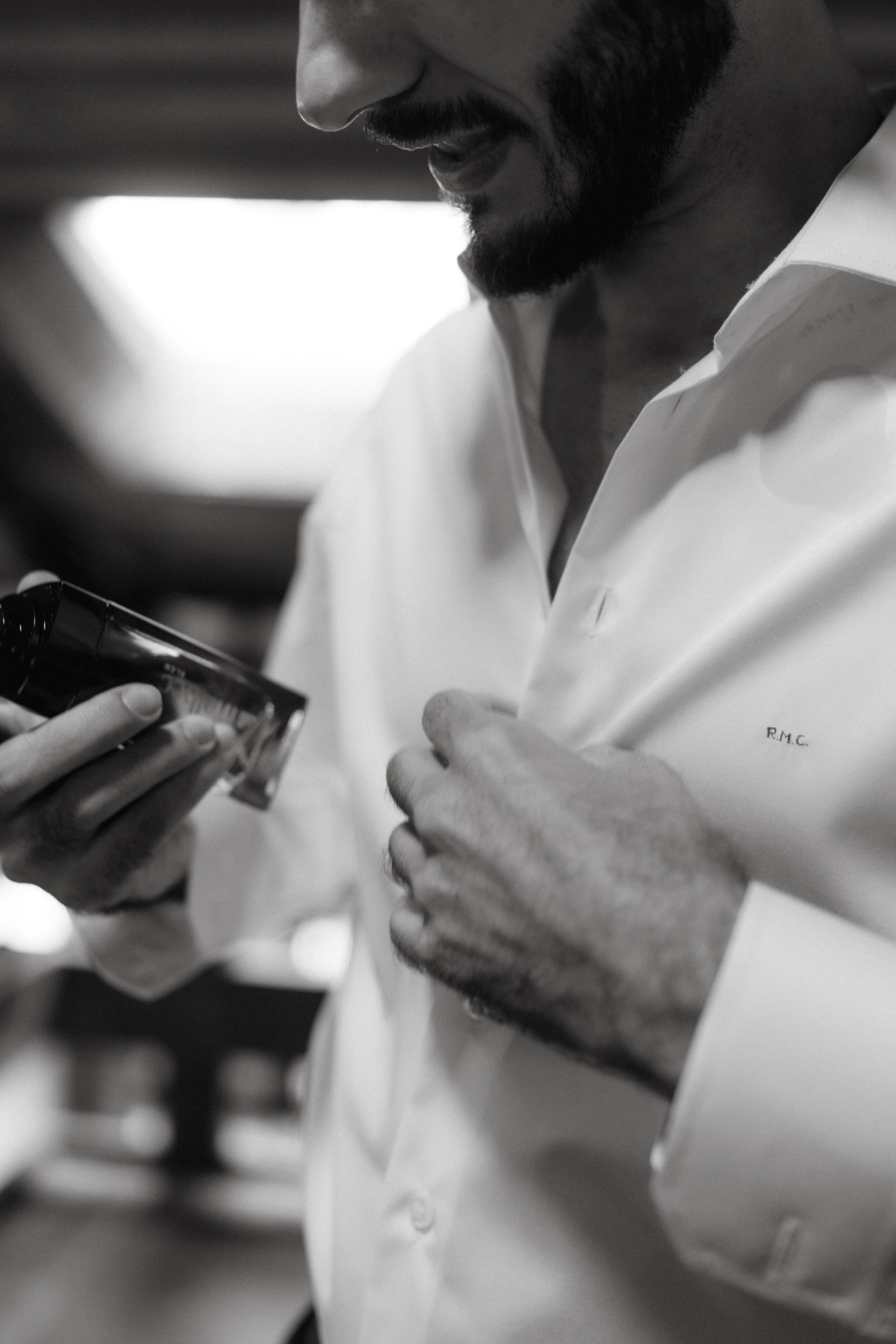 Black and white detail shot of someone adjusting formal attire.