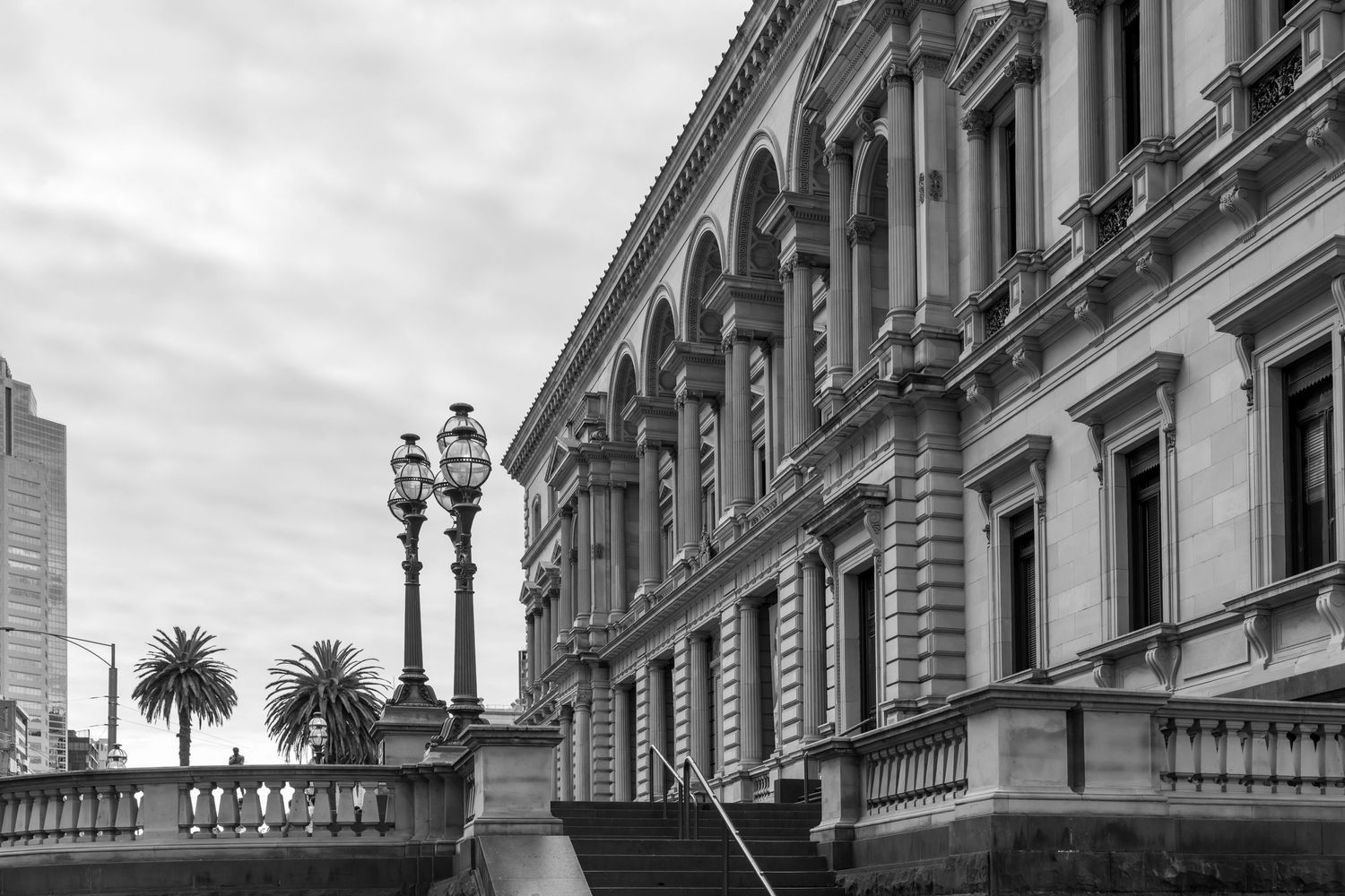 Historic ornate building facade with classical architecture and lamp posts.