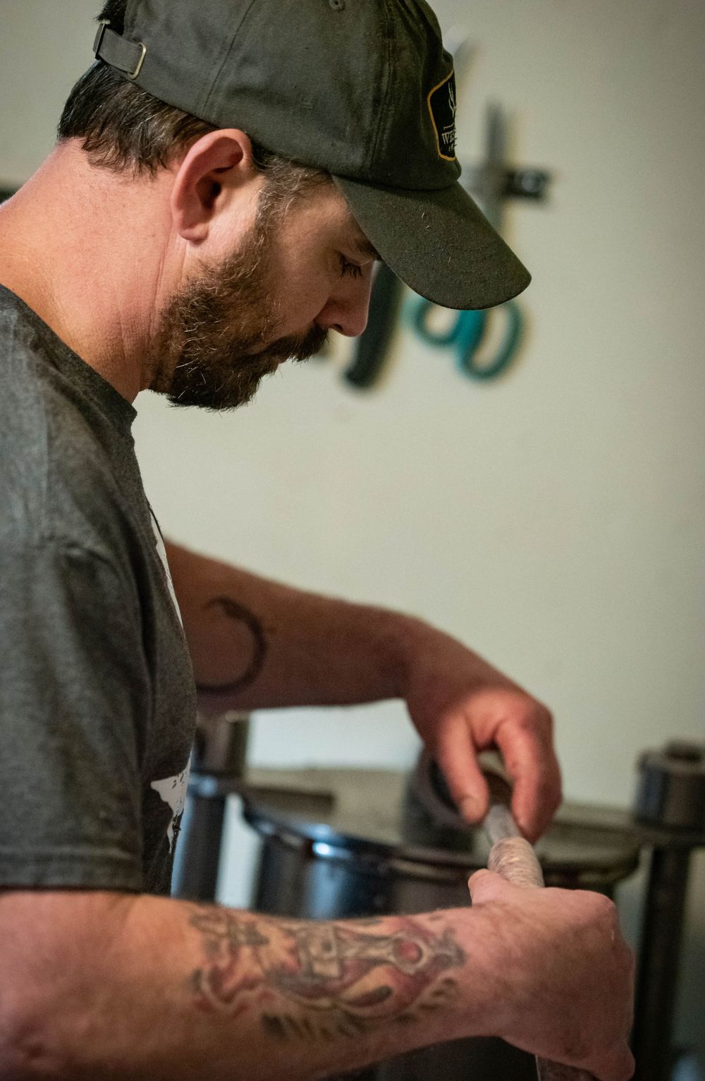 Close-up of someone wearing a dark cap preparing food in a kitchen setting.