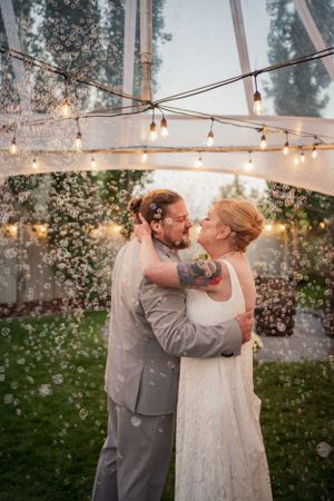 A romantic wedding dance under twinkling string lights at dusk.