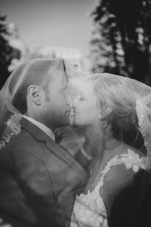 An intimate black and white wedding portrait under a delicate veil.