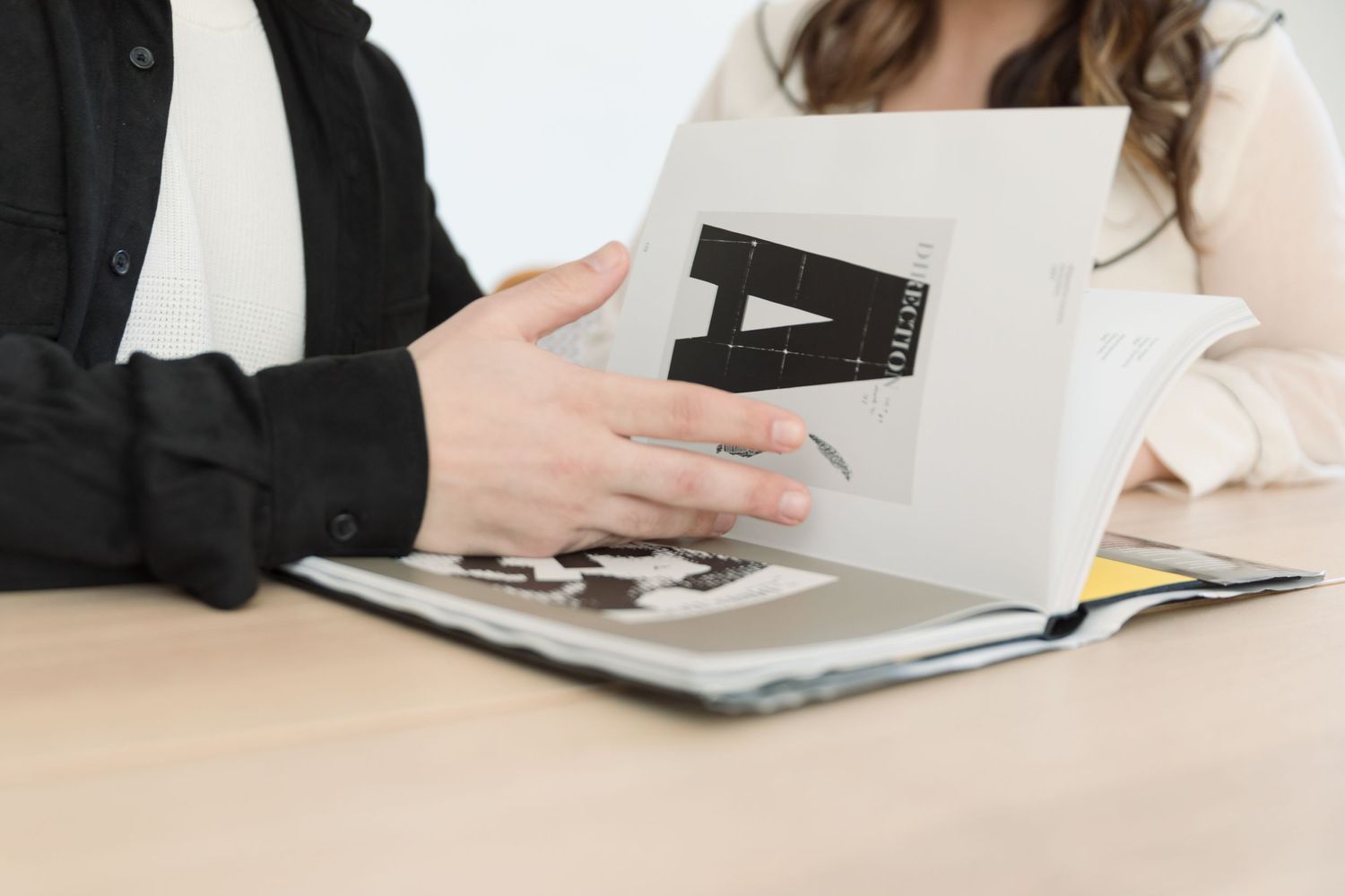 Hands holding and reviewing documents and paperwork during a business meeting.