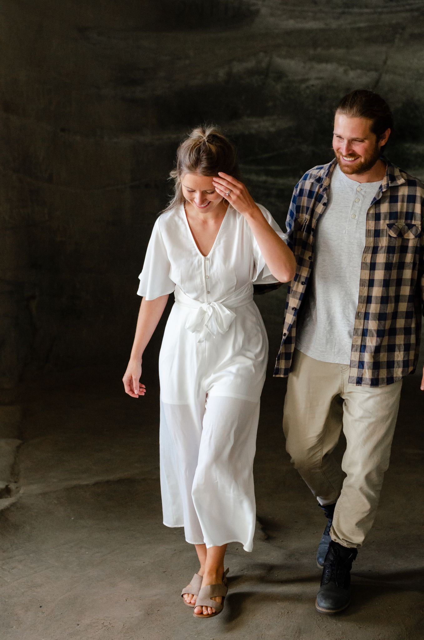 Candid walking shots of couple in white and plaid clothing against dark background.