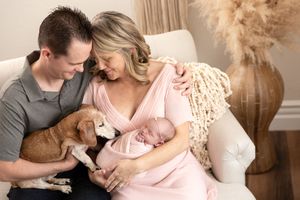 Intimate family photography session with newborn in warm neutral tones and macrame wall decor.