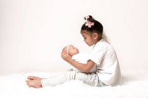 Minimalist white studio photography session with soft lighting and gentle poses.