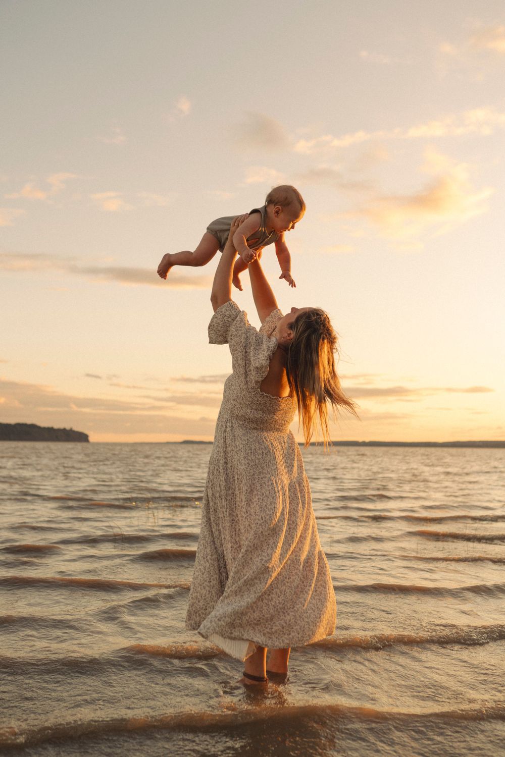 A magical sunset moment at the beach with flowing dress and joyful play.