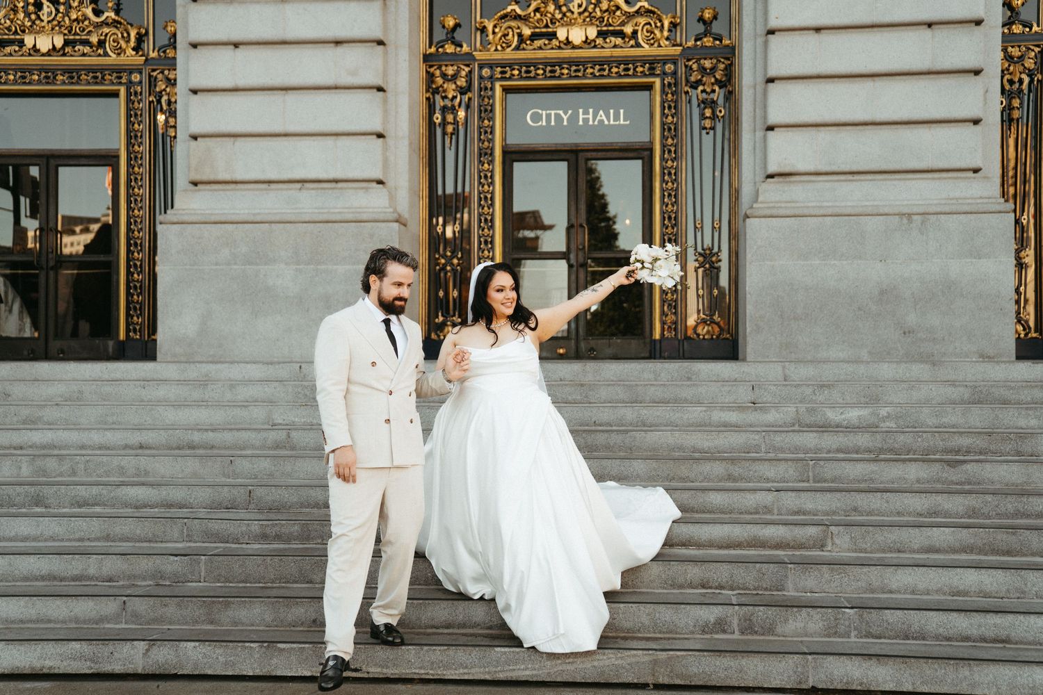 A family cheers as a newly married couple does a dip kiss outside of San Francisco City Hall.