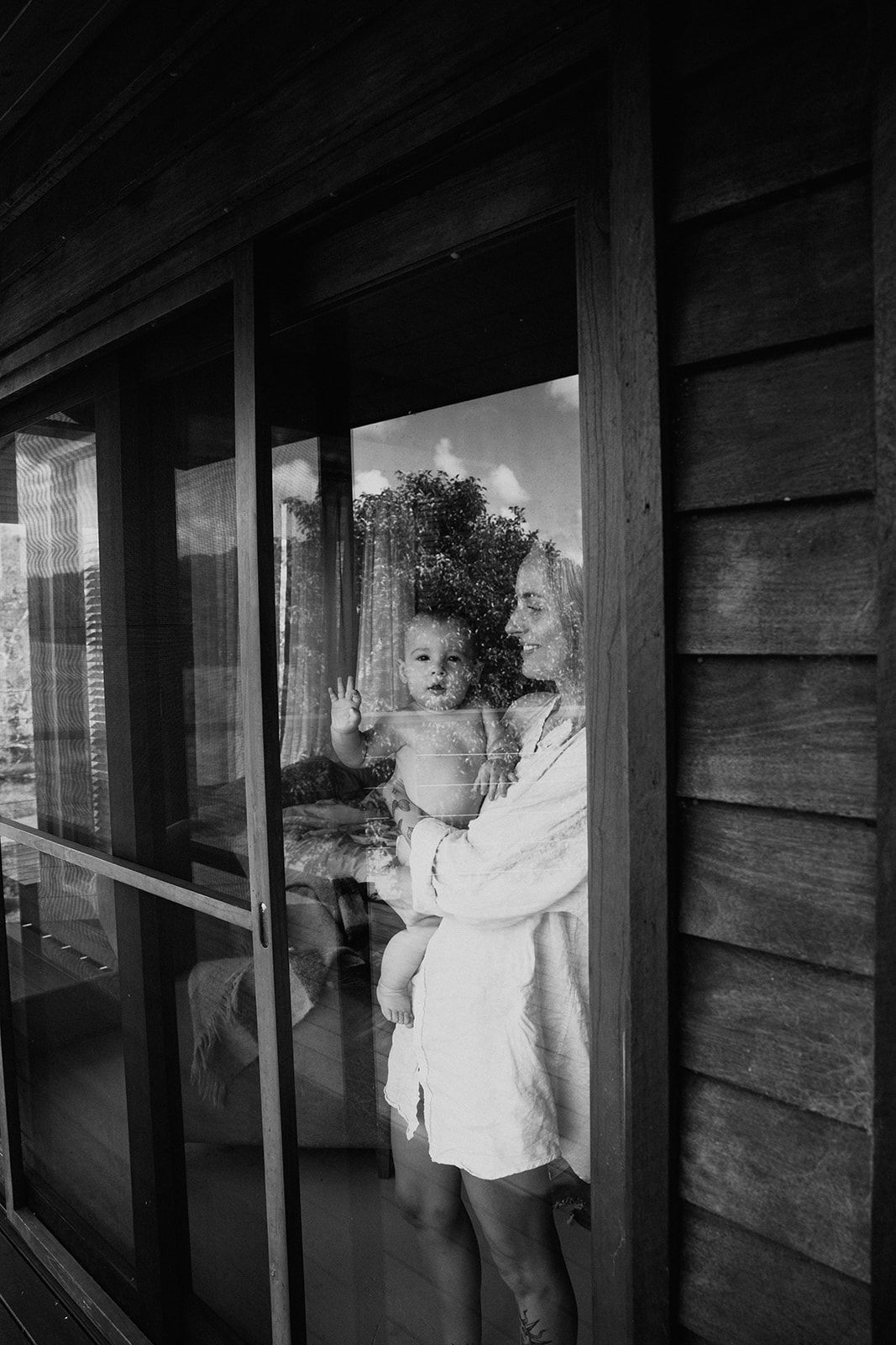 A sequence of black and white photographs showing two people embracing near a wooden wall in dim lighting.