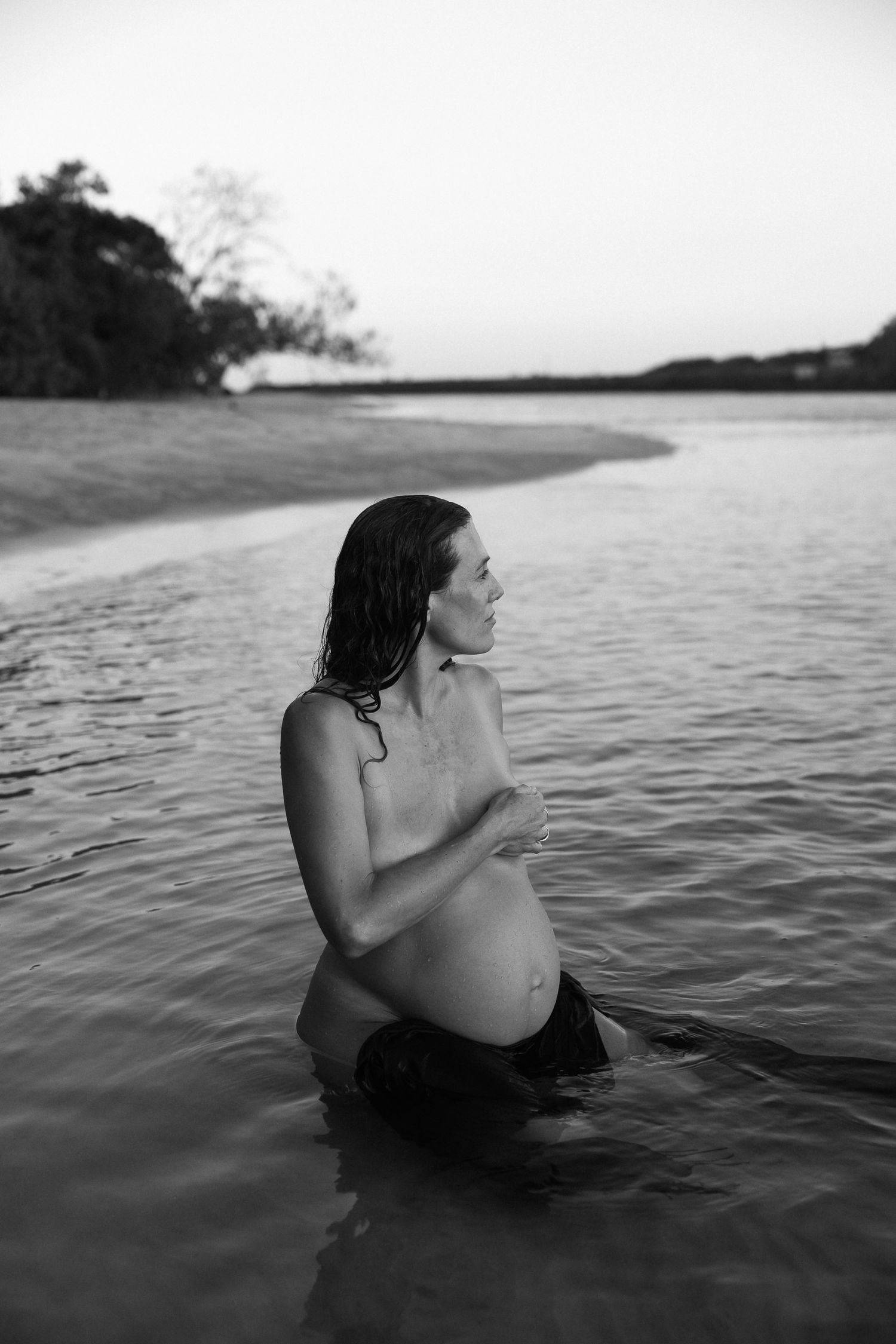 A series of black and white photos shows a figure in dark clothing floating in calm waters at dusk.