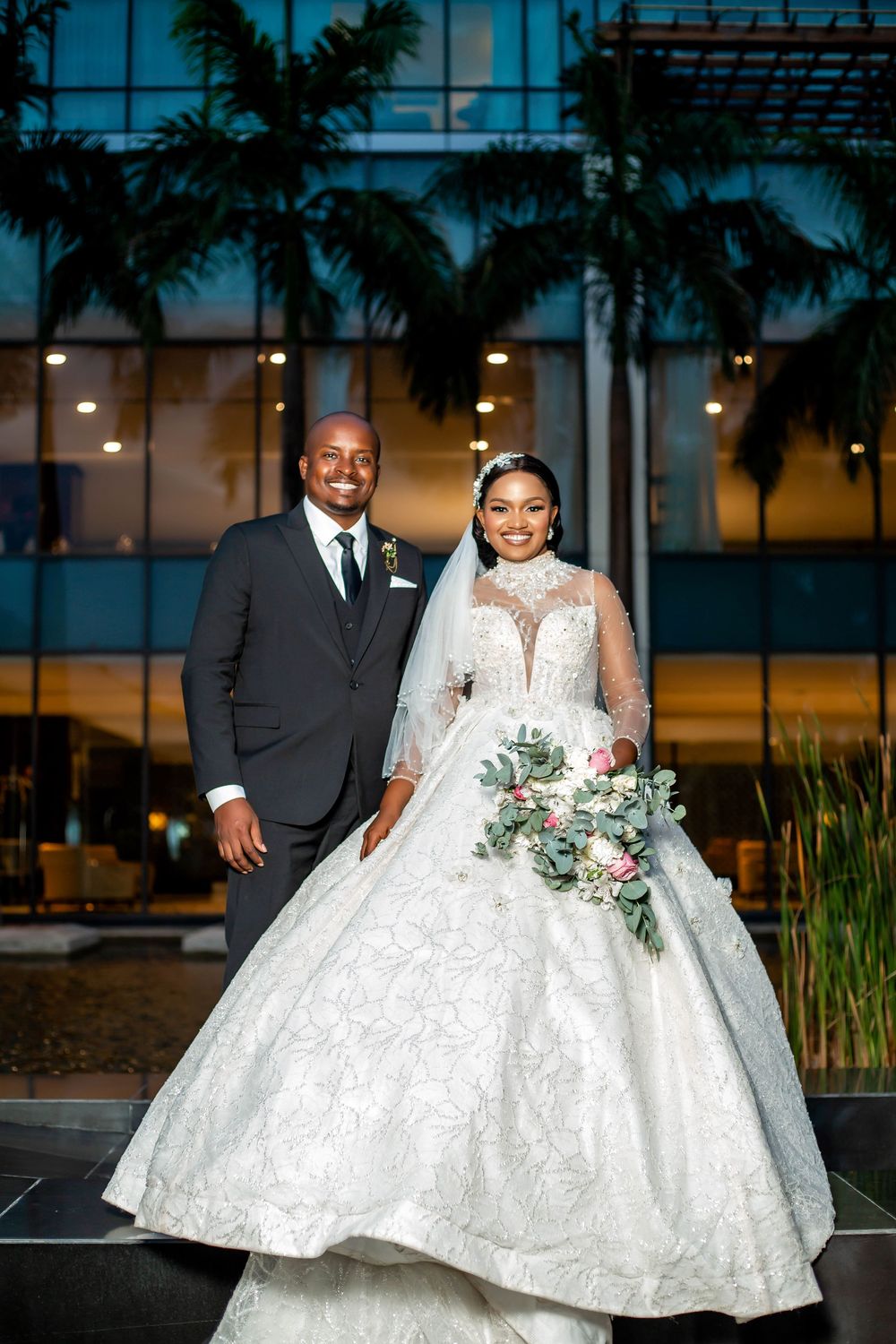 Wedding couple poses at sunset with palm trees and a gorgeous ballgown dress.
