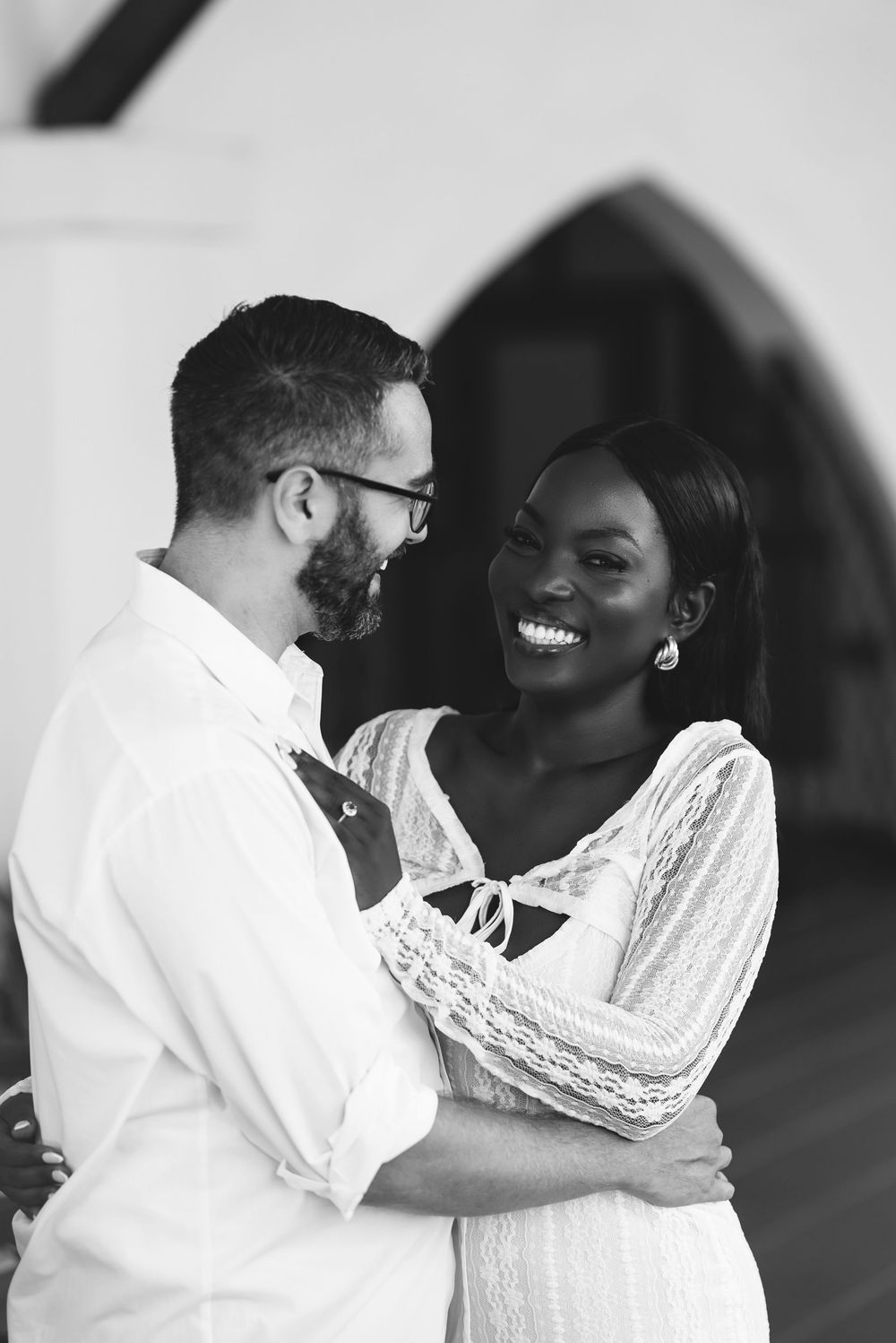 Black and white portrait of couple sharing intimate moment during engagement session.