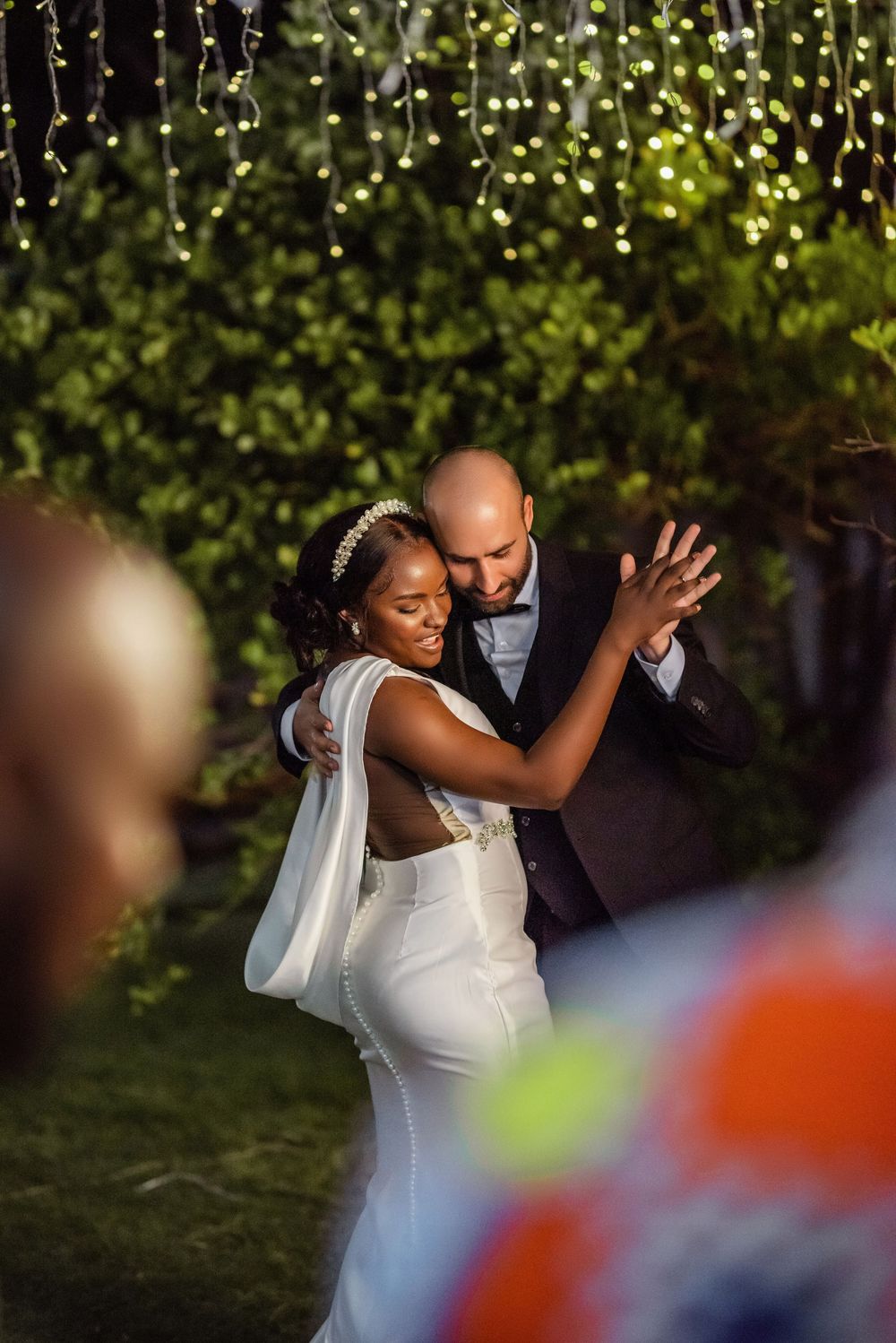 A couple dances together outdoors during a romantic garden wedding celebration.