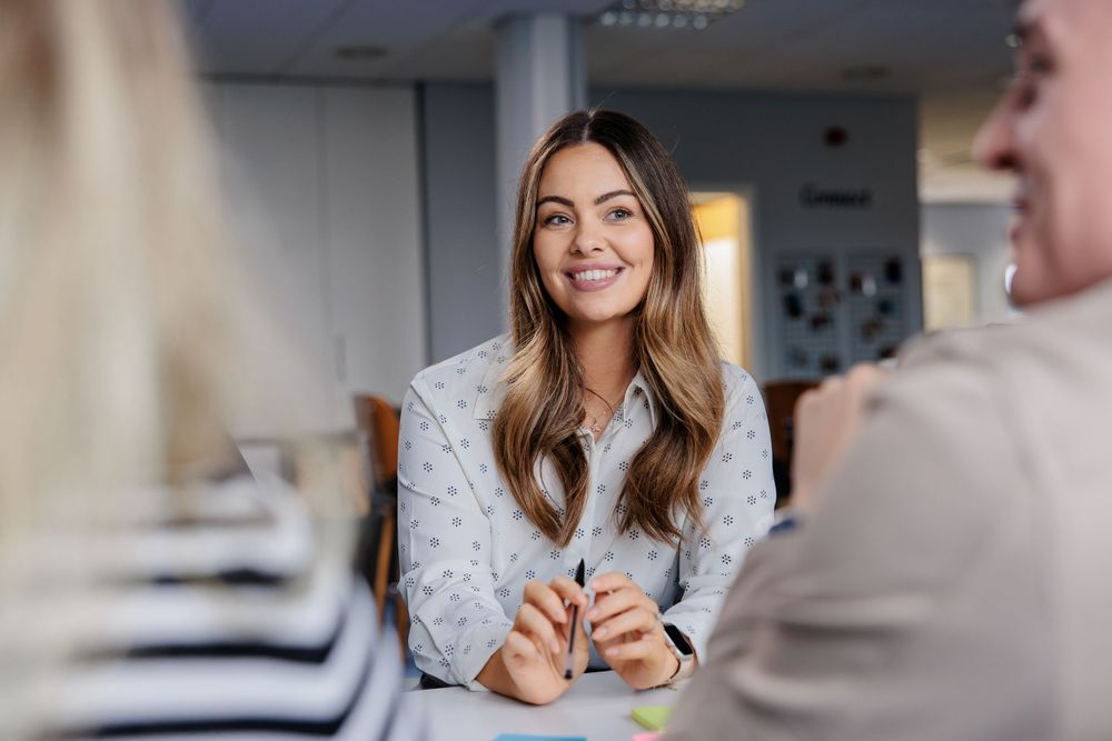 Professional engaged in conversation during bright modern office meeting.