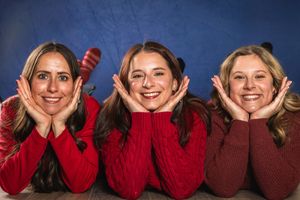 A group wearing red and brown sweaters poses together in a casual holiday photo series.