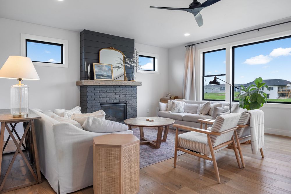 Modern coastal living room with grey fireplace and contemporary furnishings.