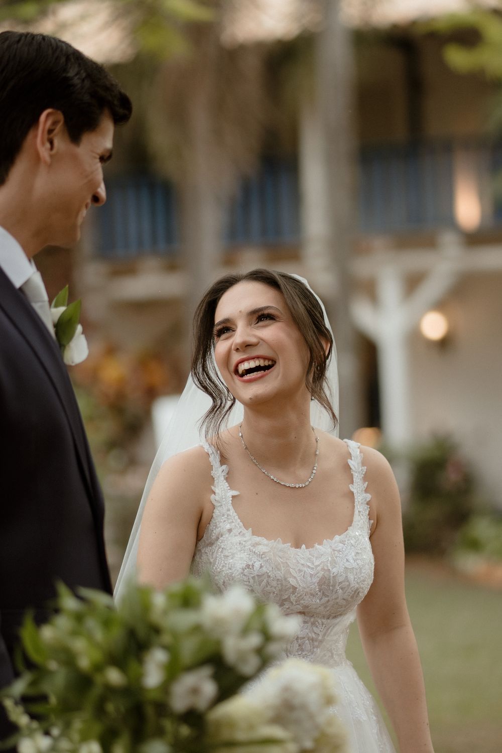 A joyful wedding couple shares candid moments during their outdoor garden ceremony.