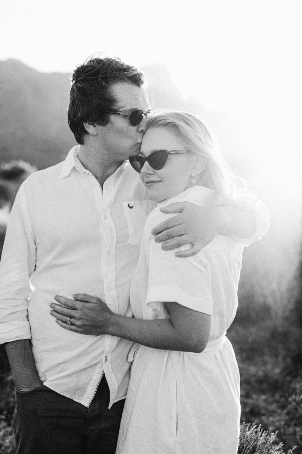b&W moment with a girl being kissed on her forehead by her husband to be