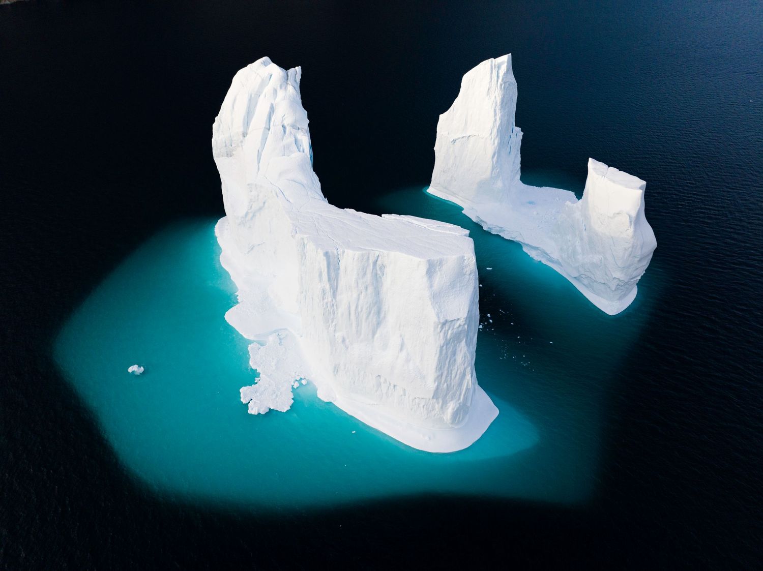 Glowing blue ice caves with dramatic lighting and ethereal formations in a dark underground setting.
