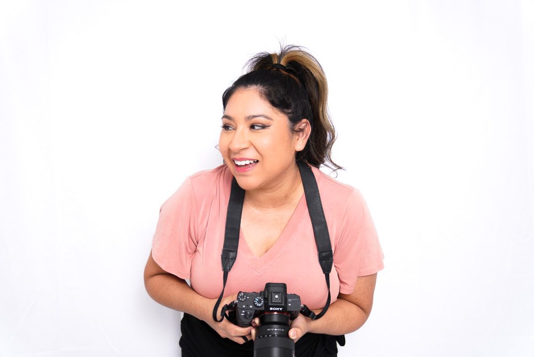 Brisbane based professional photographer holding a camera, ready to capture high-quality images