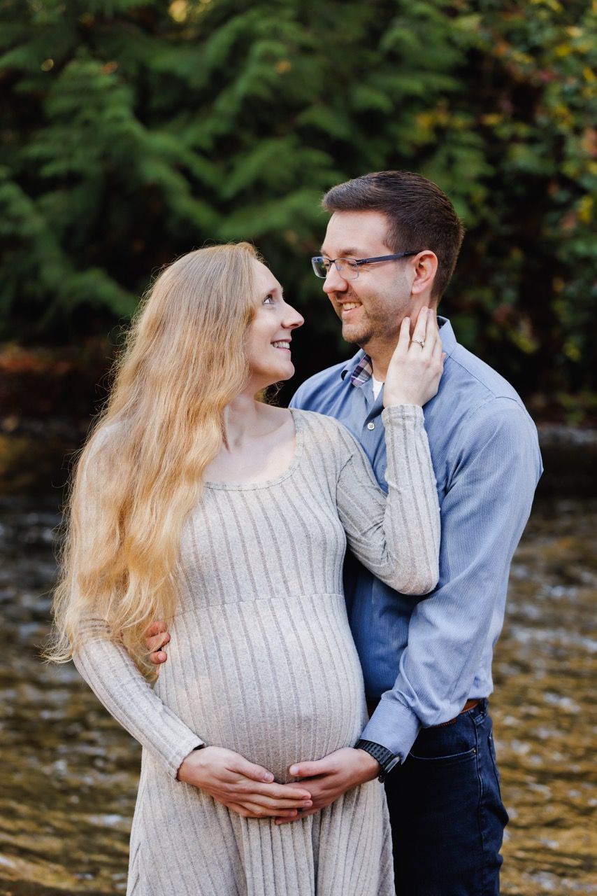 Expecting parents embracing in a Snohomish field. Intimate and affectionate maternity photography by Tim Neal.