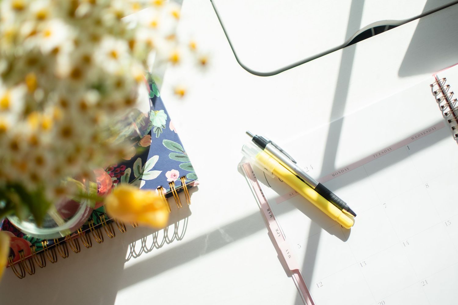 Colorful desk scene with party hat, pencil and floral background.