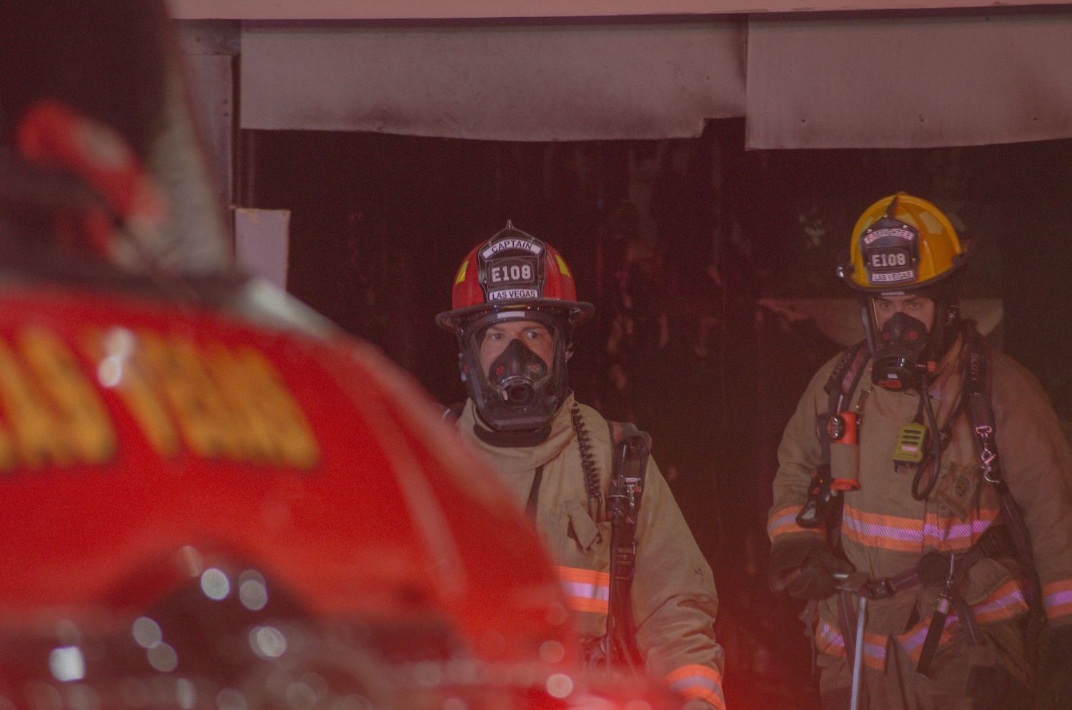 Emergency responders with helmets and equipment at a nighttime scene.
