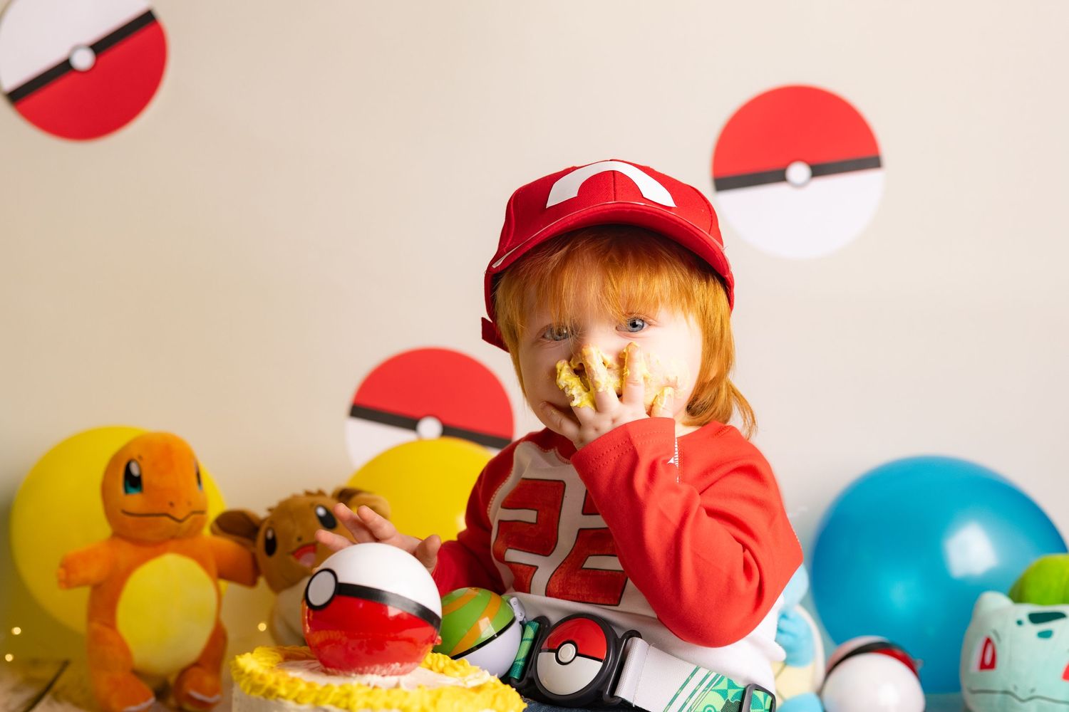 A Pokemon-themed party setup with red and white Pokeball decorations, balloons, and themed party supplies.