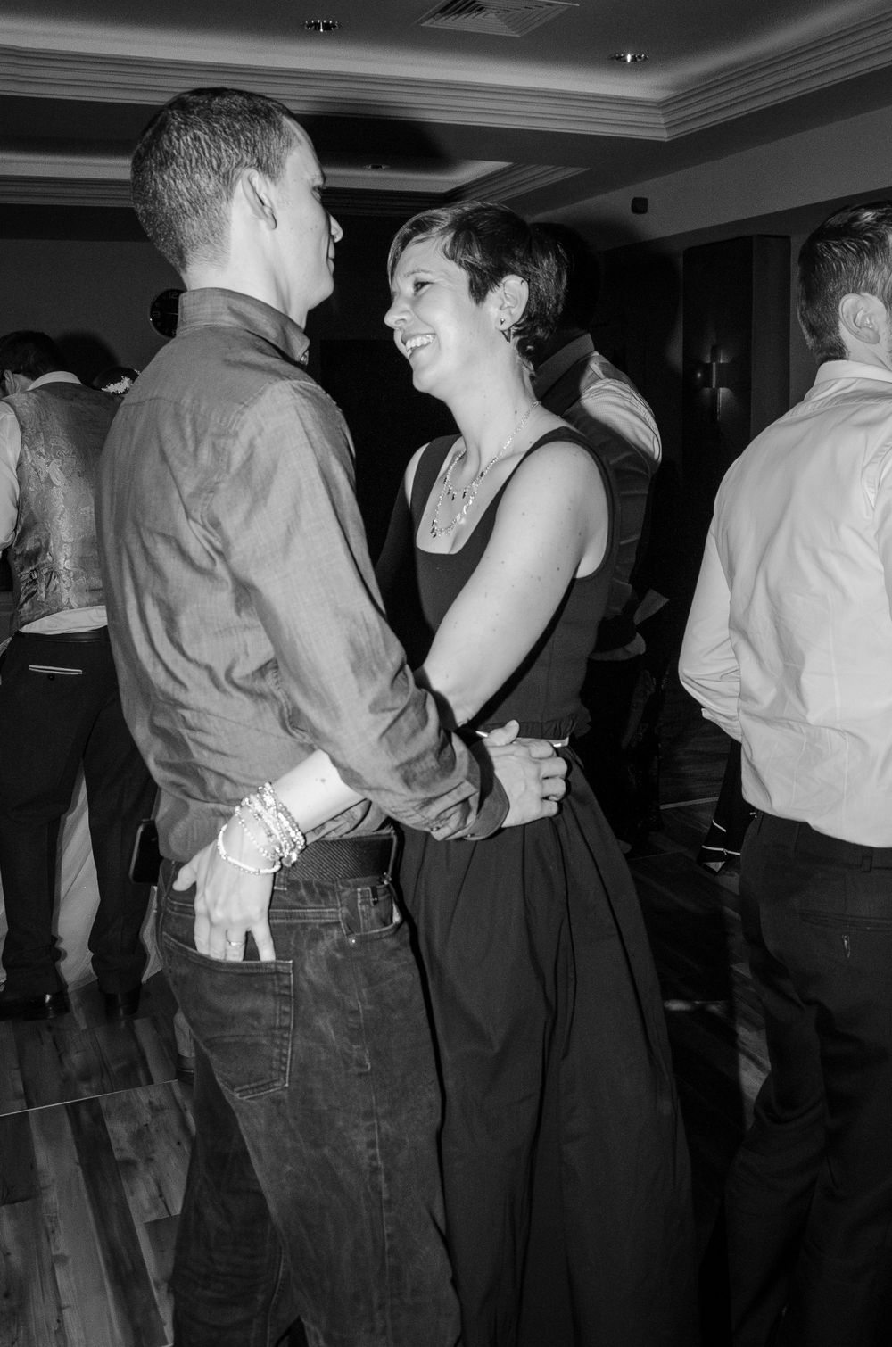 Black and white photo of couple dancing closely at indoor event.