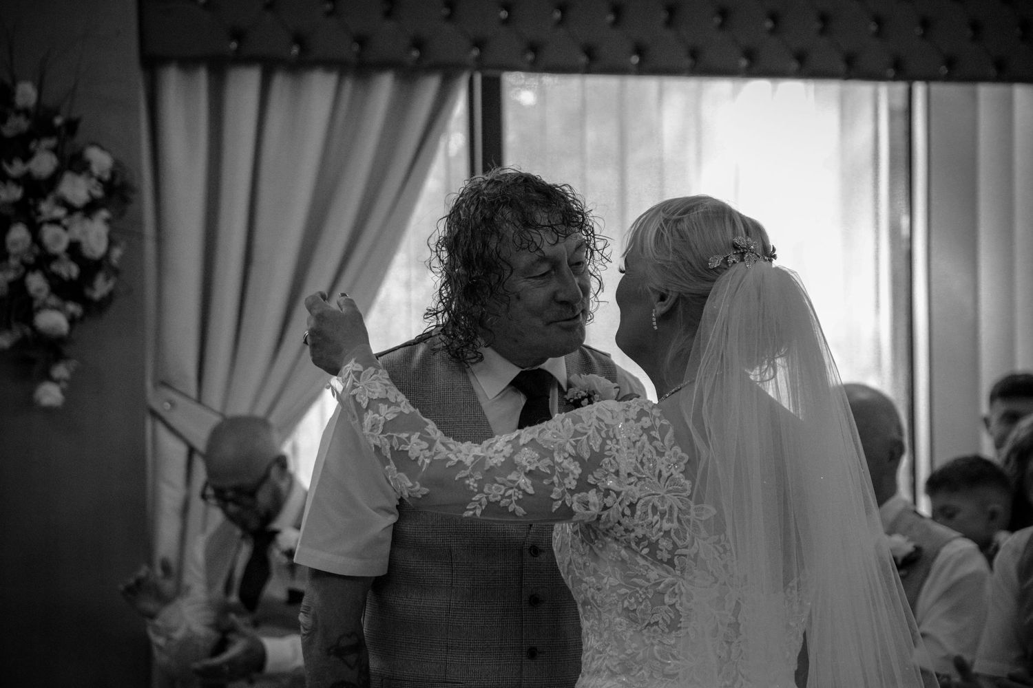 Black and white candid moment during an indoor wedding celebration.