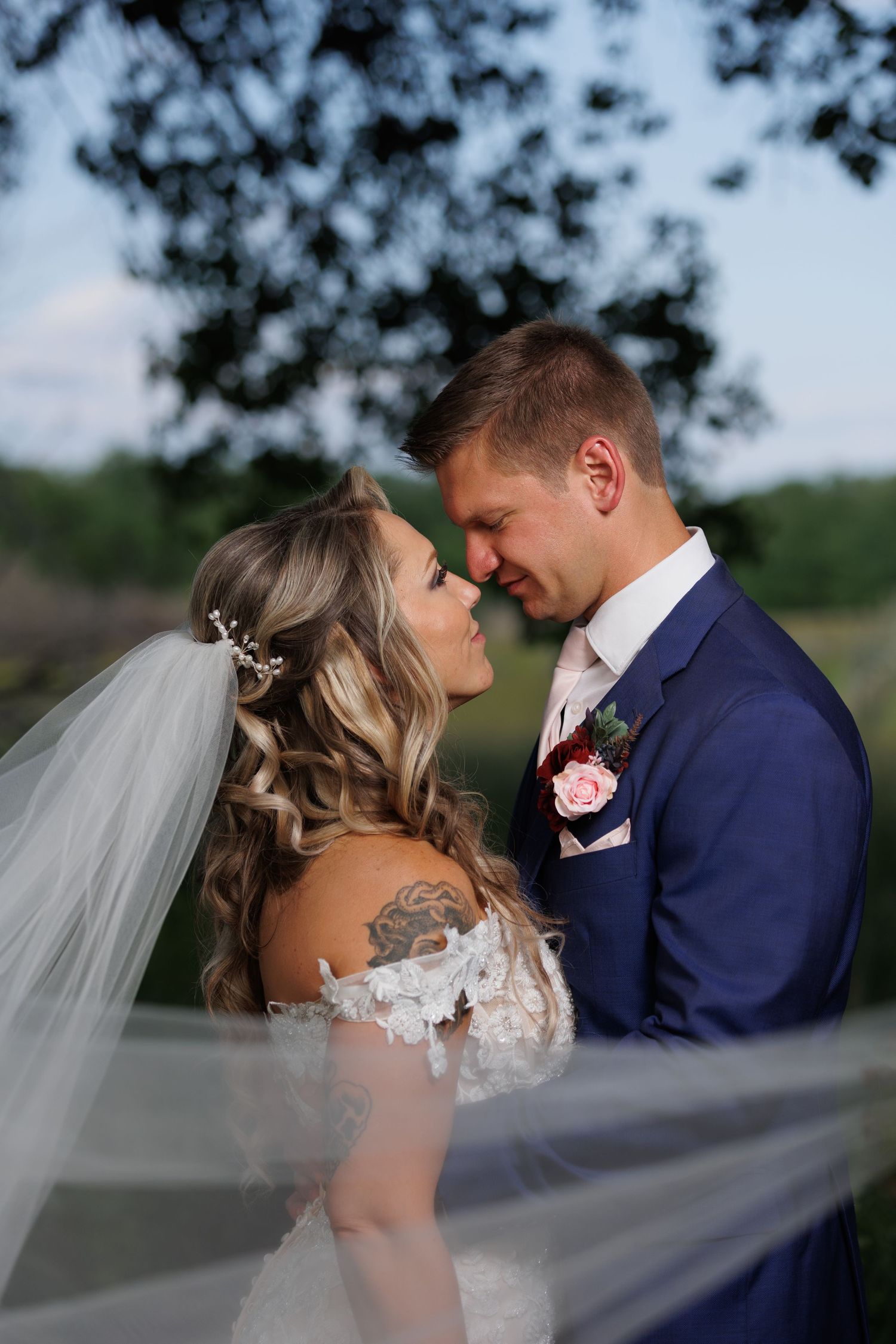 Newly married couple standing by a pond, having a few quiet moments just after their ceremony.