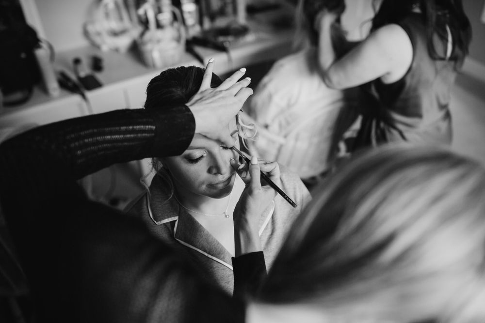 Black and white candid photograph showing preparation and styling for a special event or performance.