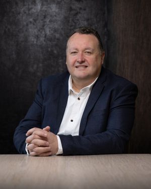 Business professional headshot with confident expression and studio lighting