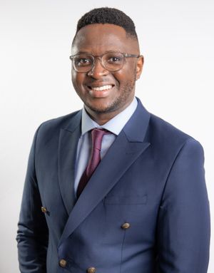 Business professional headshot with confident expression and studio lighting