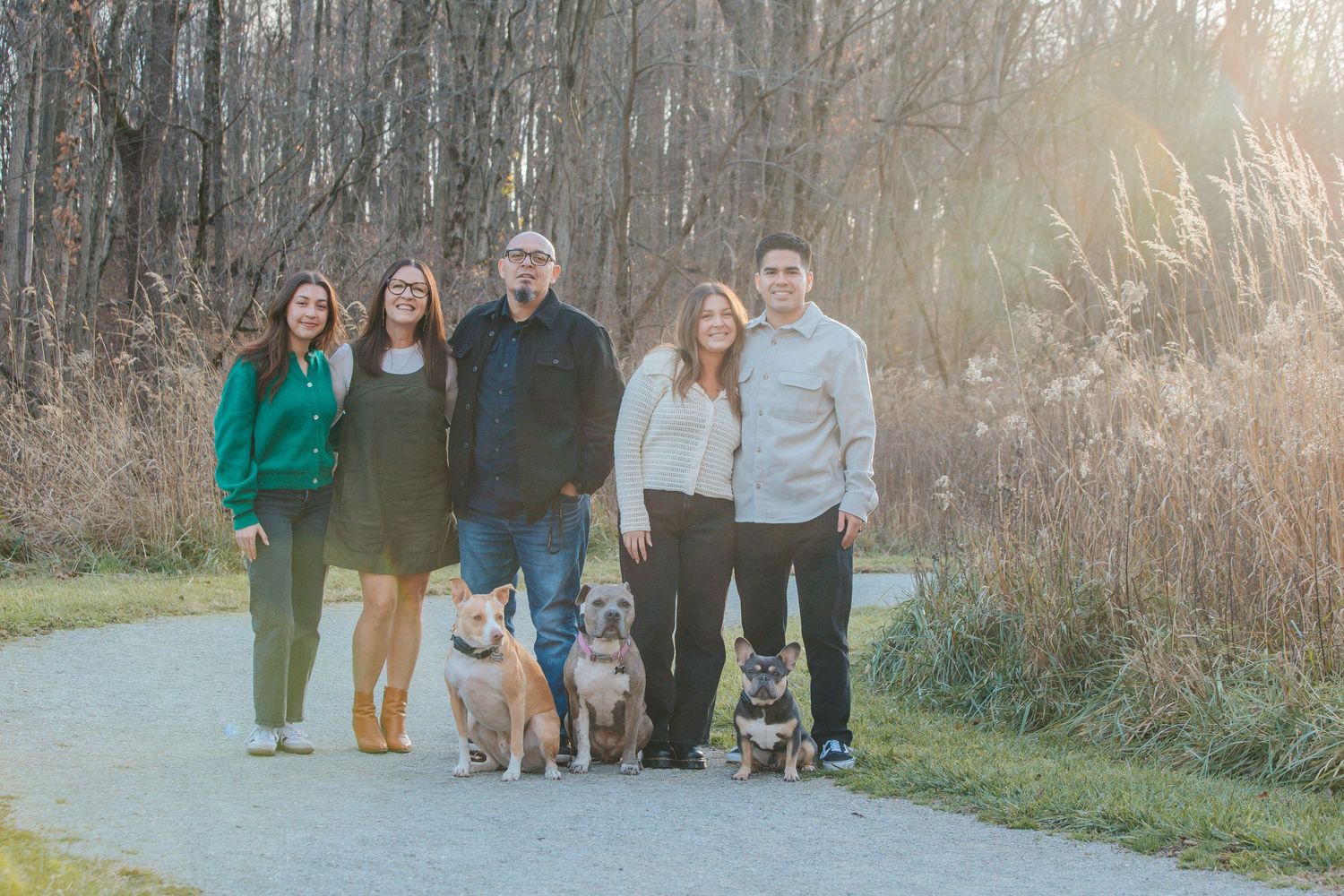 Outdoor family gathering captured during golden hour with fall colors in background.