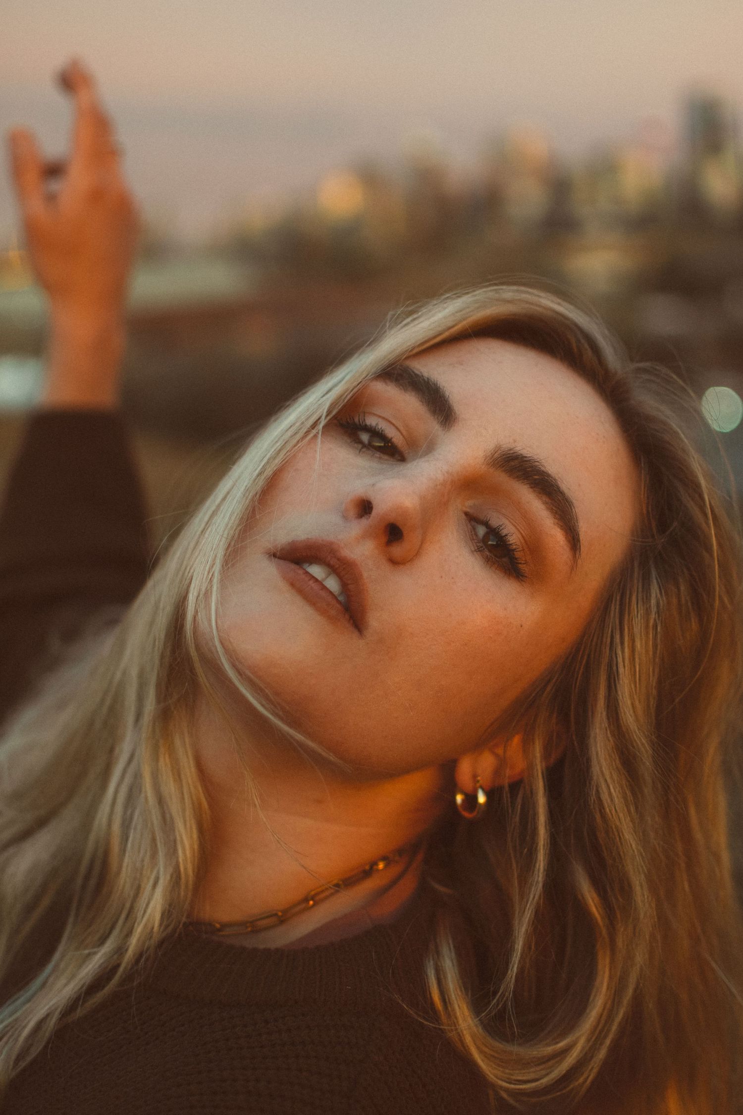 Portrait of a woman with blonde hair in golden sunset lighting.