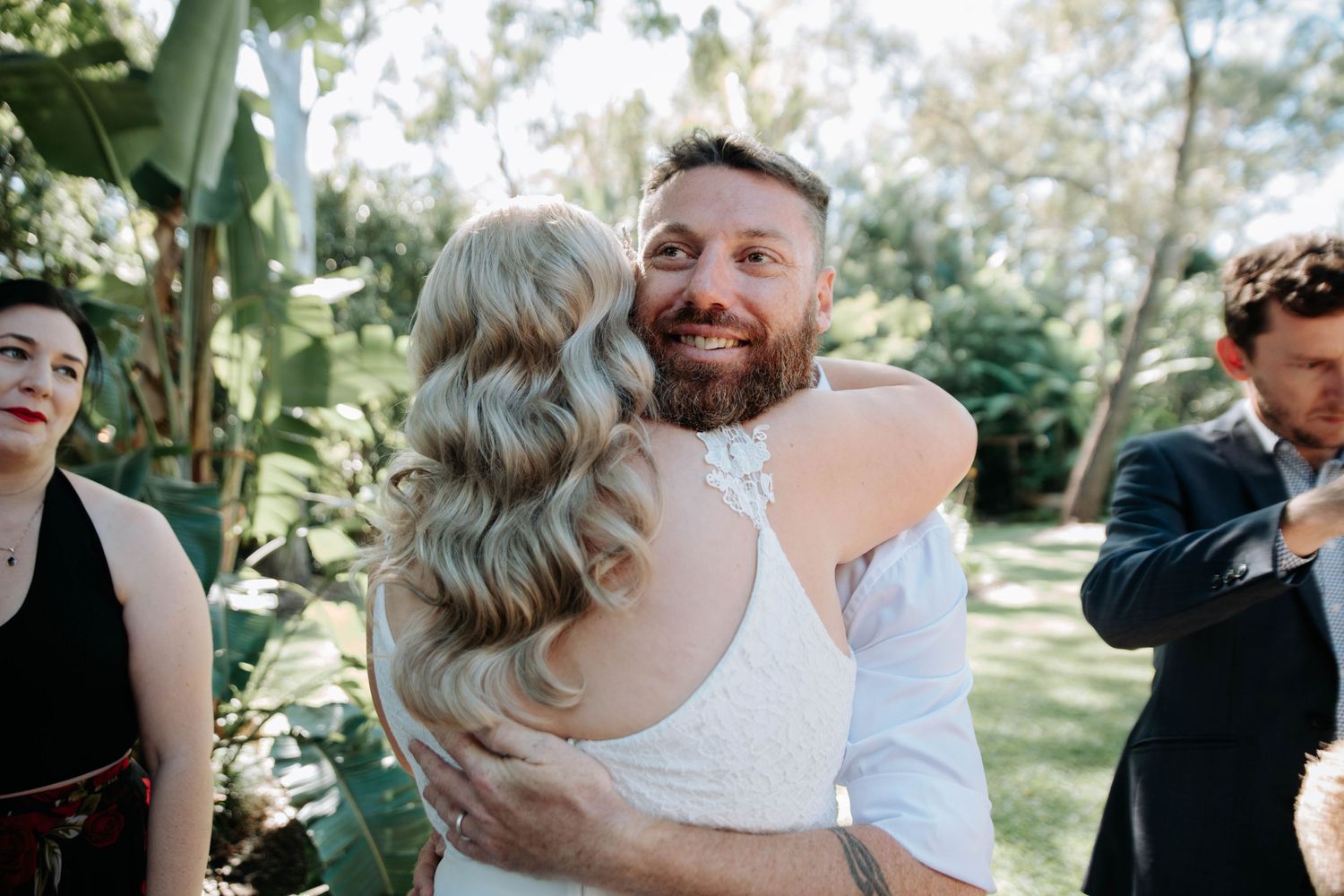 An emotional embrace during an outdoor garden wedding celebration.