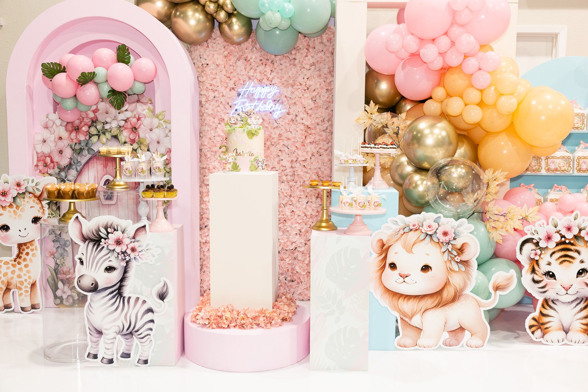 Safari-themed party decorations featuring pink arch, pastel balloons, and cute animal designs.