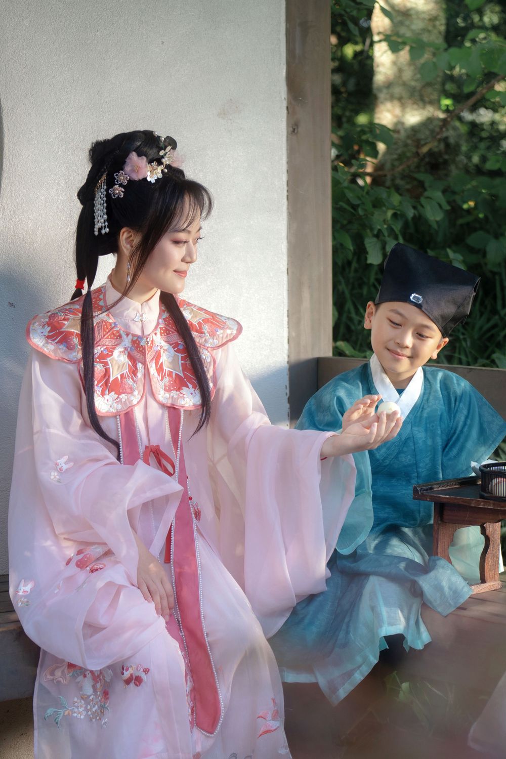 Candid natural light Hanfu family portrait of parents playing happily with kids at Botanic Garden Auckland, by Imagine Image Studio.