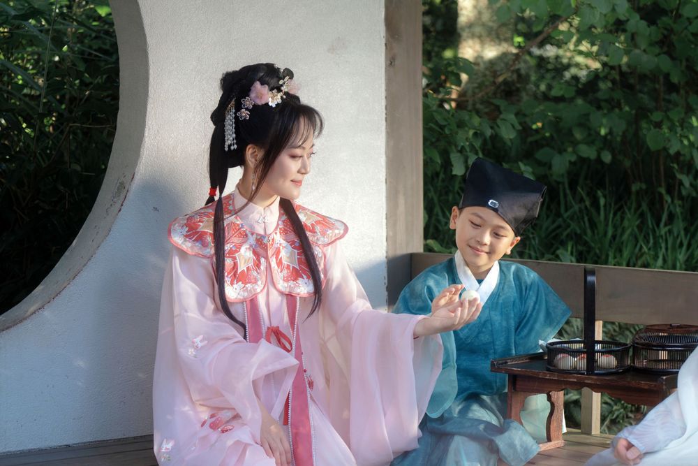 Candid natural light Hanfu family portrait of parents playing happily with kids at Botanic Garden Auckland, by Imagine Image Studio.