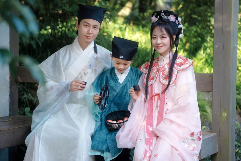 Candid natural light Hanfu family portrait of parents playing happily with kids at Botanic Garden Auckland, by Imagine Image Studio.