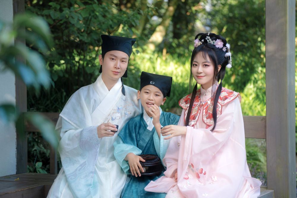 Candid natural light Hanfu family portrait of parents playing happily with kids at Botanic Garden Auckland, by Imagine Image Studio.