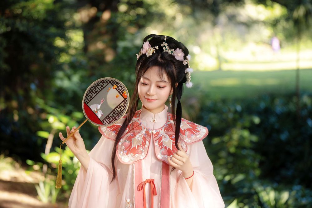 Candid natural light Hanfu family portrait of parents playing happily with kids at Botanic Garden Auckland, by Imagine Image Studio.