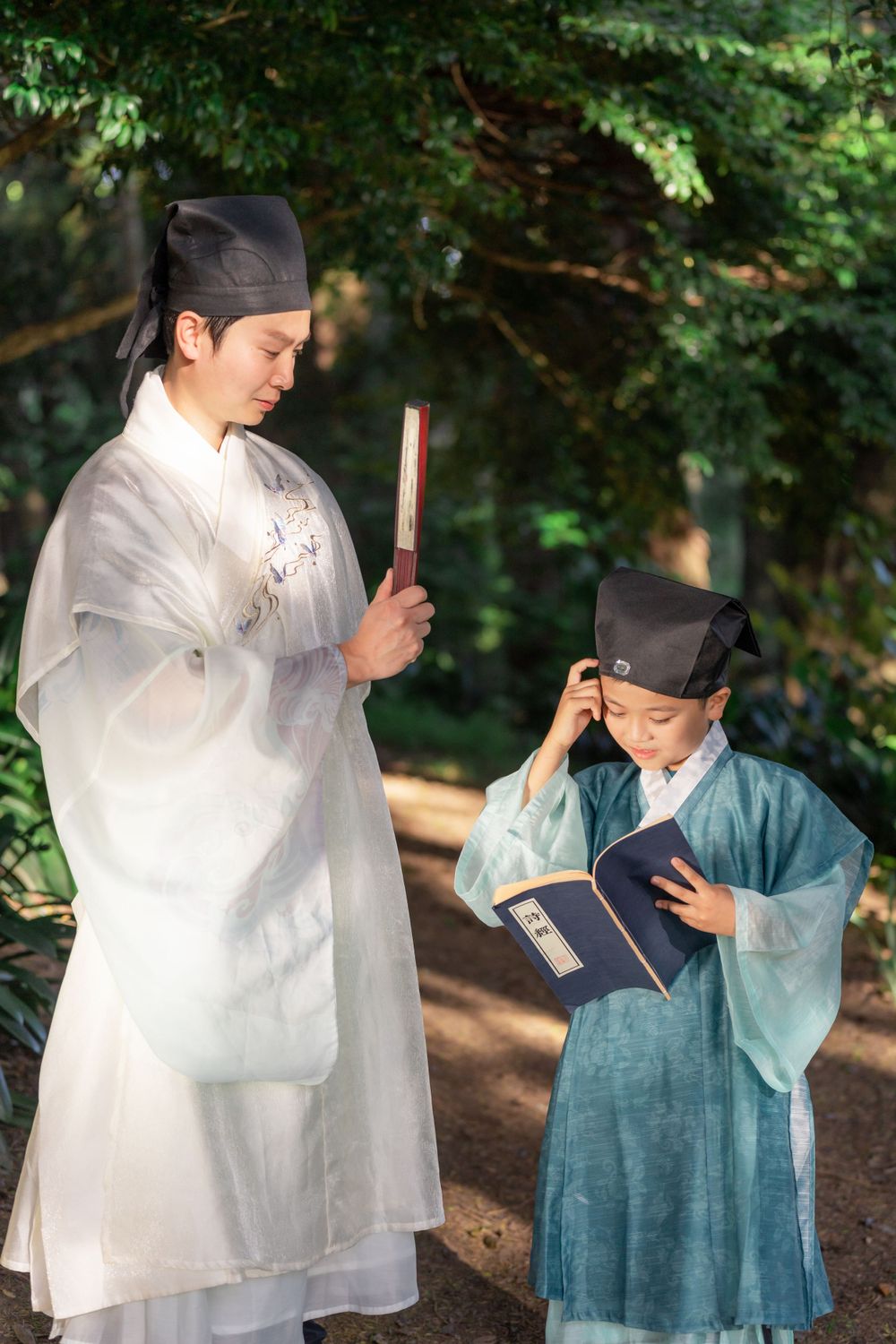 Candid natural light Hanfu family portrait of parents playing happily with kids at Botanic Garden Auckland, by Imagine Image Studio.
