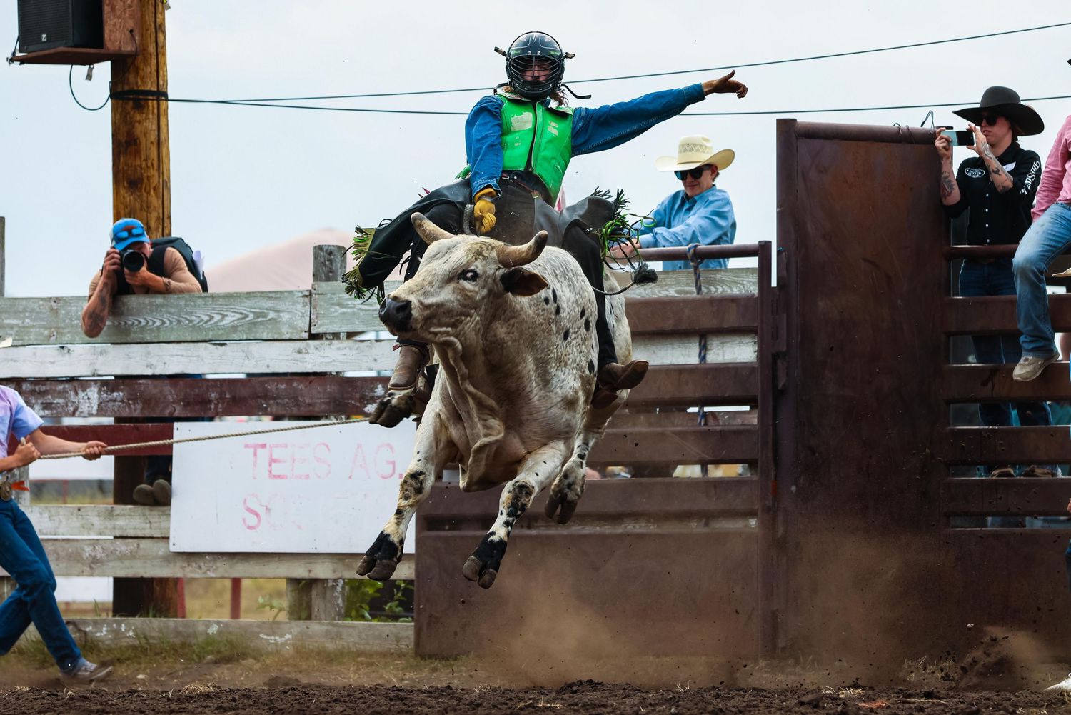 Bull rider in action during intense rodeo competition moment.