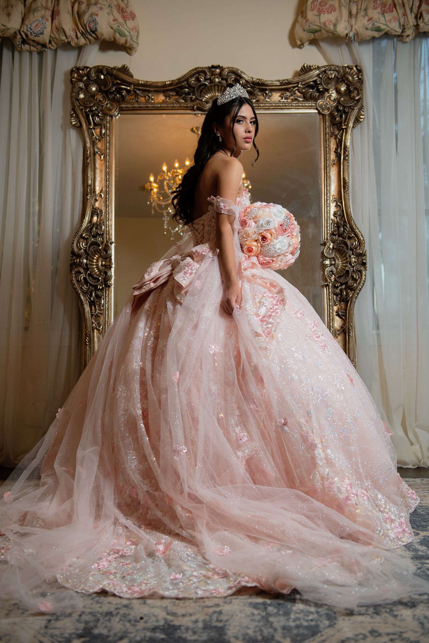 A stunning hot pink quinceañera dress with gold embellishments and off-shoulder design.