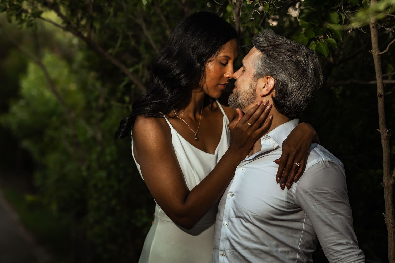 Couple shares intimate moment under umbrella in the rain.
