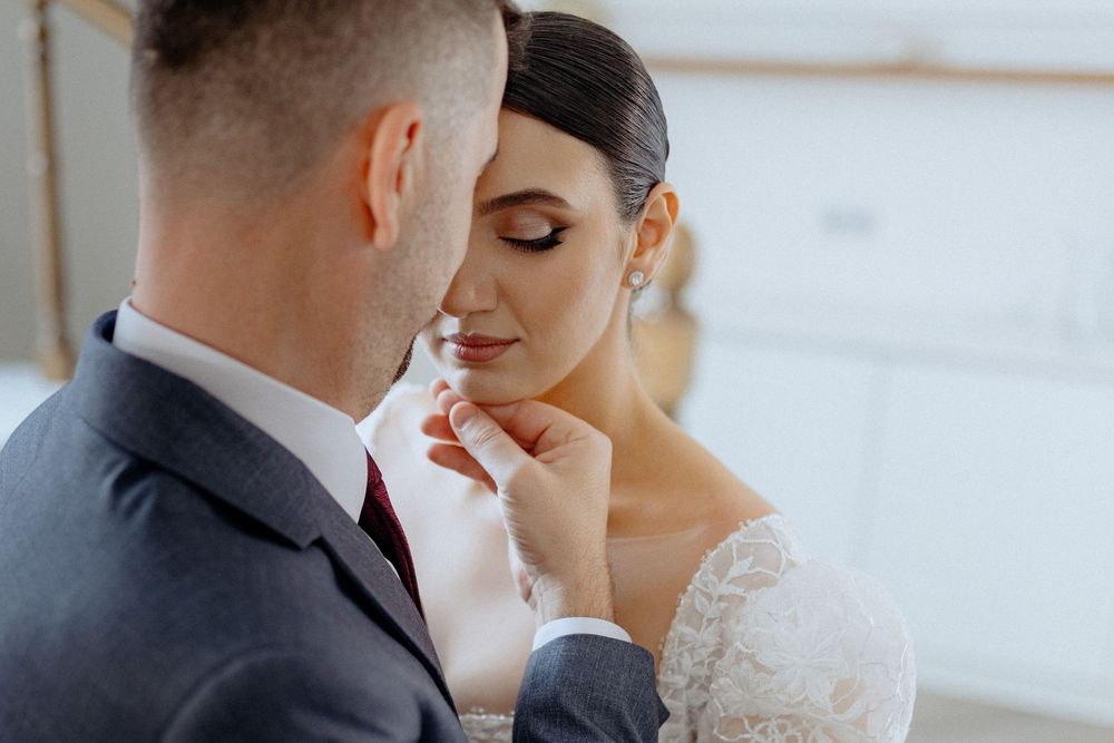 Romantic wedding couple sharing intimate moments in a series of tender poses against a bright window backdrop.
