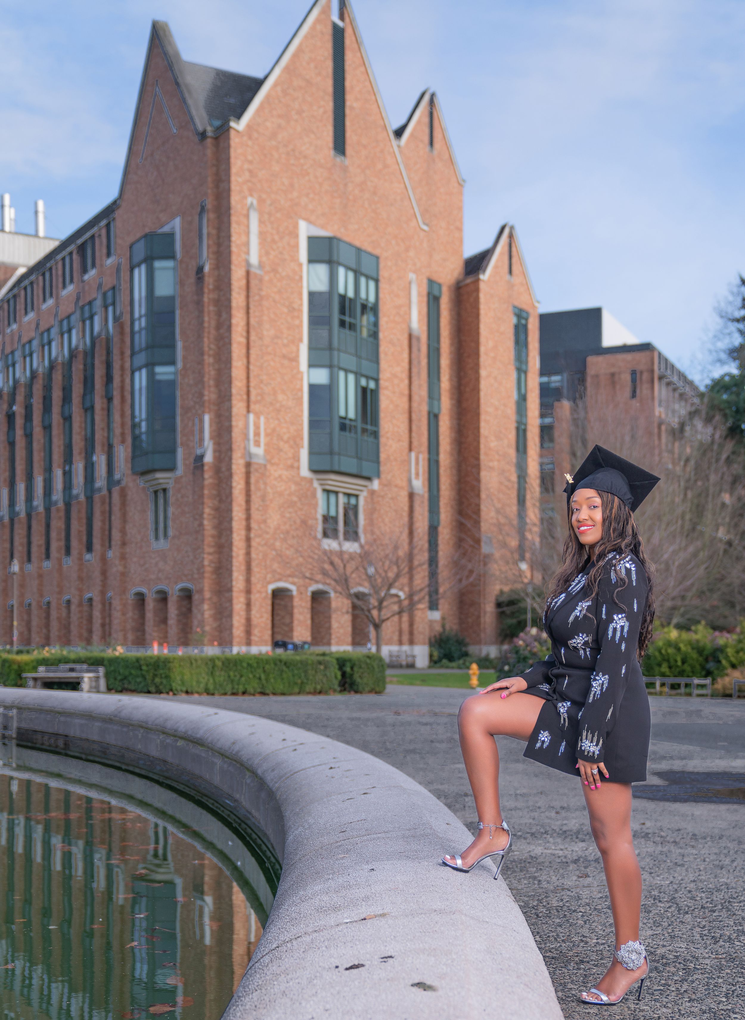 Modern red brick university building with Gothic-inspired architecture and reflective glass windows creates a striking campus view.