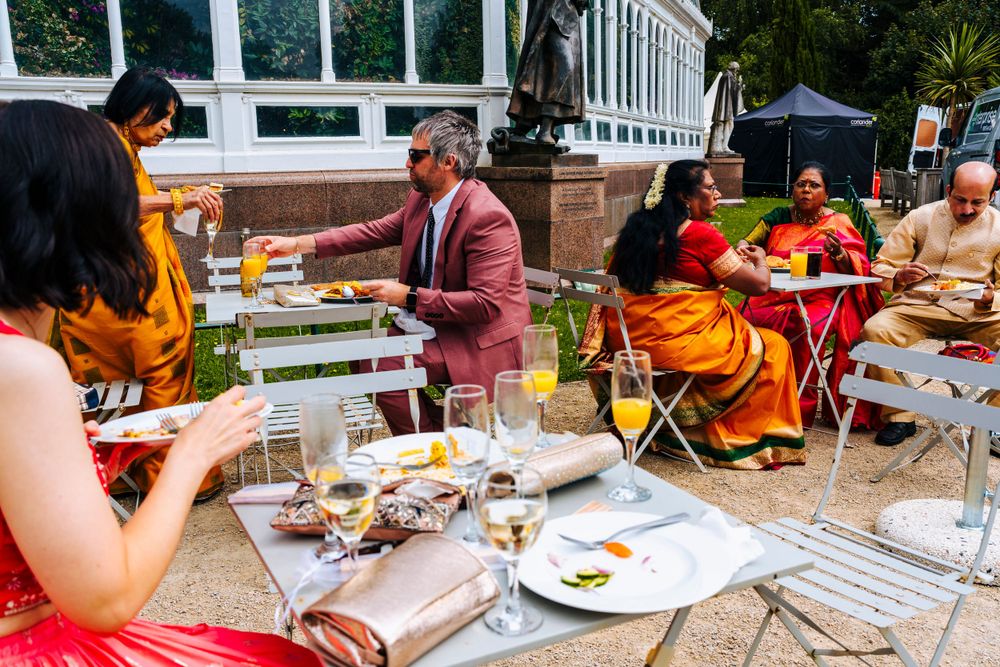Wedding guests enjoying food outside of sefton park palm house