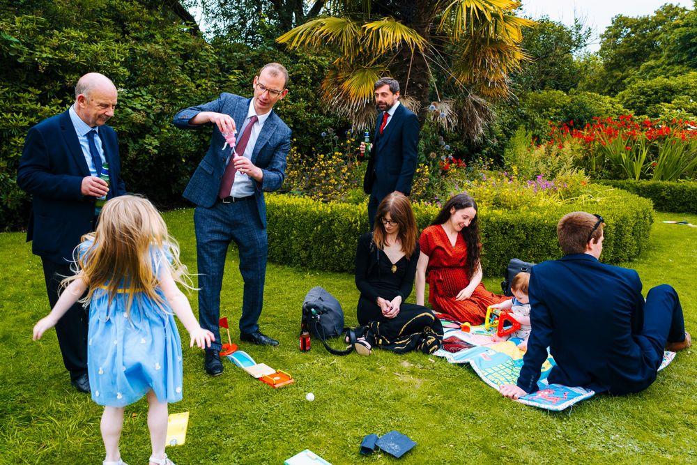Wedding guests playing and enjoying things outside of sefton park palm house